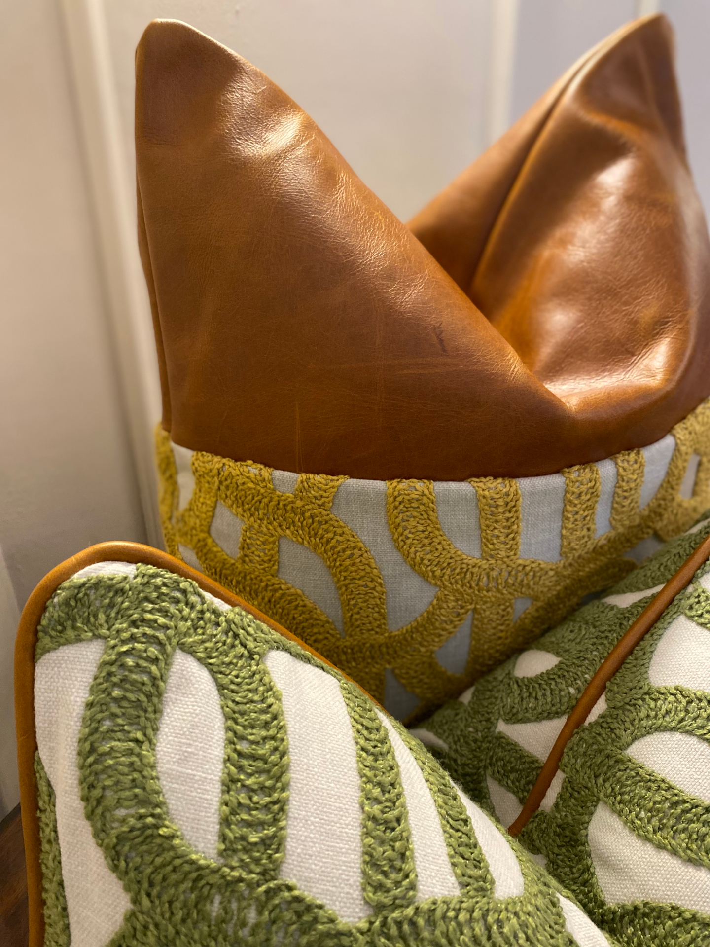 Full-grain tan leather cushion paired with hand-loomed emerald trellis weave