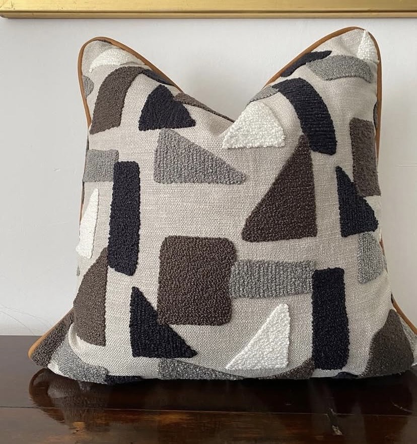 Textured geometric scatter cushion in charcoal, stone and ivory with tan leather piping